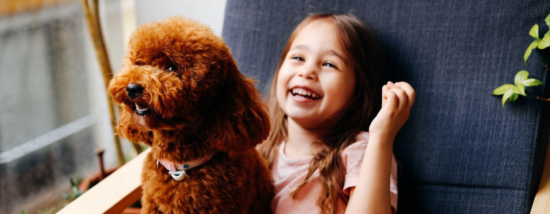 a girl sitting next to a dog